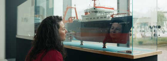 Frau schaut sich ein Schiff an | © Tim David-Müller Zitzke/Dennis Vogt