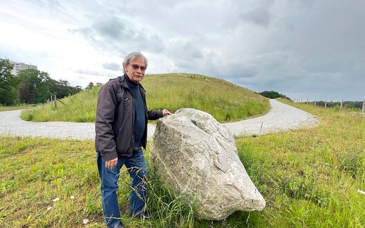 Mann steht vor einem großen Stein. | © BIS/Stop press - Helmut Stapel