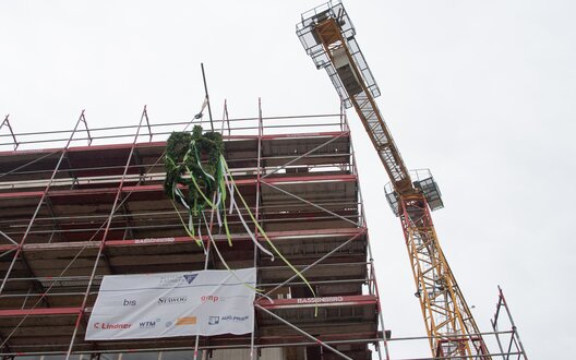 Der Richtkranz ziert das zukünftige Schulzentrum Hamburger Straße (SHS) im Rahmen des Richtfests von der Allianz 3 Schulen.  | © STÄWOG / Heiko Sandelmann