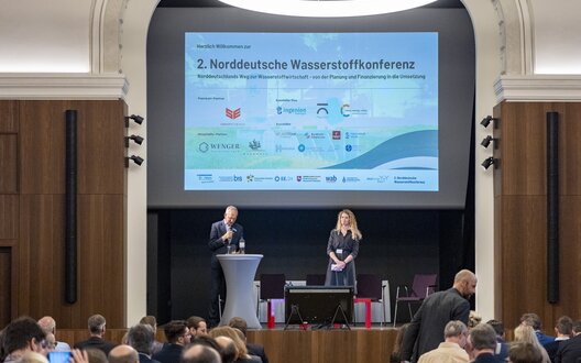 Auf der 2. Norddeutschen Wasserstoffkonferenz in Hamburg steht der Austausch über notwendige Maßnahmen für den Markthochlauf der Wasserstoffwirtschaft in Deutschland im Mittelpunkt. (Auf dem Bild v.l.: Jan Rispens, Erneuerbare Energien Hamburg mit Lis Blume, Niedersächsisches Wasserstoffnetzwerk). | © Henning Anger