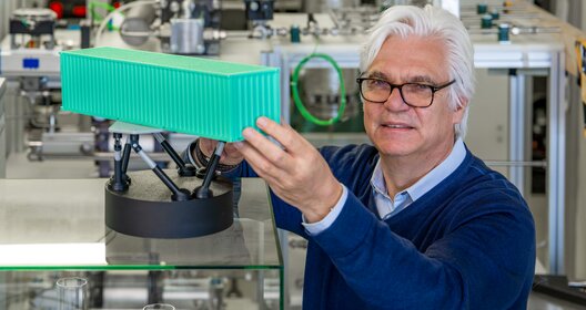 Prof. Dr.-Ing. Gerhard Schories mit einem Modell des Seegangssimulators